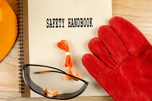 Emanet şapka, eldiven, gözlük, kulak tıkacı ve not defteri. Sağlığı ve güvenliği kavramı.