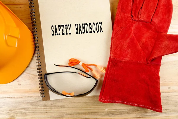 Emanet şapka, eldiven, gözlük, kulak tıkacı ve not defteri. Sağlığı ve güvenliği kavramı.