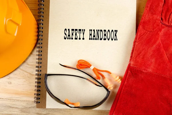 Emanet şapka, eldiven, gözlük, kulak tıkacı ve not defteri. Sağlığı ve güvenliği kavramı.