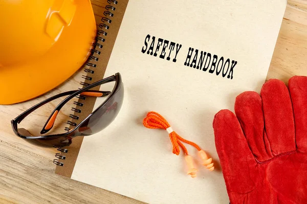 Emanet şapka, eldiven, gözlük, kulak tıkacı ve not defteri. Sağlığı ve güvenliği kavramı.