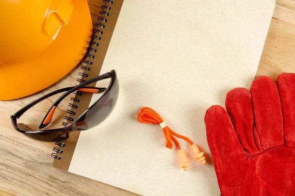 Emanet şapka, eldiven, gözlük, kulak tıkacı ve not defteri. Sağlığı ve güvenliği kavramı.