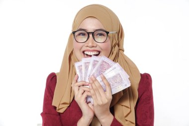 Mutlu bir şekilde tutarak ve beyaz bir arka plan üzerinde izole para gösterilen güzel Bayan