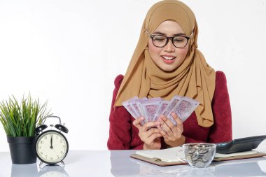 Mutlu bir şekilde tutarak ve beyaz bir arka plan üzerinde izole para gösterilen güzel Bayan