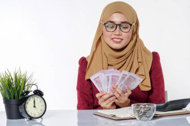 Mutlu bir şekilde tutarak ve beyaz bir arka plan üzerinde izole para gösterilen güzel Bayan