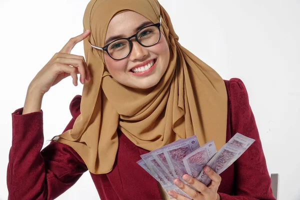 Mutlu bir şekilde tutarak ve beyaz bir arka plan üzerinde izole para gösterilen güzel Bayan