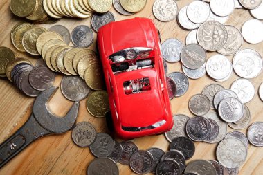 Somun anahtarı, sikke ve minyatür bir araba. Onarım ve bakım kavramı.