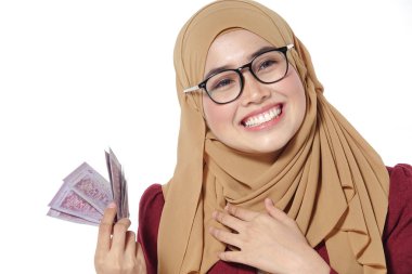 Mutlu bir şekilde tutarak ve beyaz bir arka plan üzerinde izole para gösterilen güzel Bayan