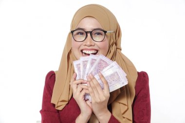 Mutlu bir şekilde tutarak ve beyaz bir arka plan üzerinde izole para gösterilen güzel Bayan