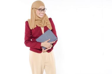 Asyalı güzel öğretmen mavi kitap izole beyaz holding.