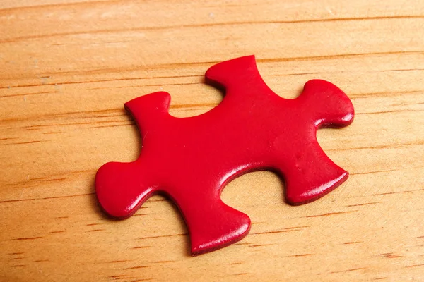 Missing red jigsaw puzzle on wooden table. Copy Space