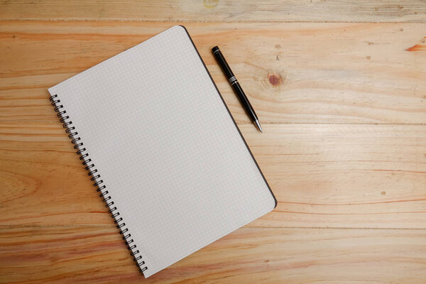 Blank notepad and coffee cup on office wooden table