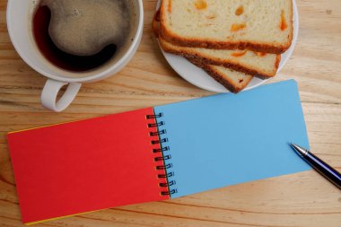 Boş not defteri ve kahve fincanı ofis tahtasının üzerinde.