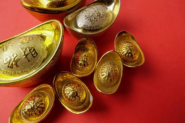 赤の背景に中国の旧正月のお祝いデコレーション用ゴールド地金 中国語の文字を意味する幸運 富と繁栄の画像で見ると — ストック写真