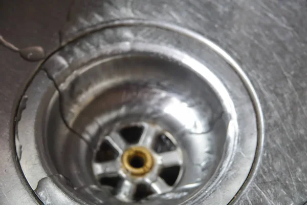 A stainless steel kitchen sink drain, detail