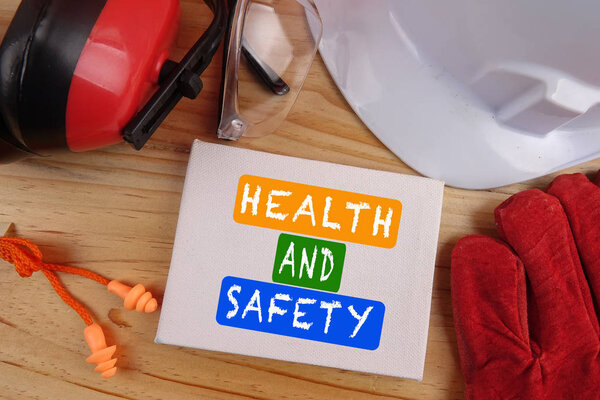 HEALTH AND SAFETY CONCEPT. Personal protective equipment on wooden table background. Copy space