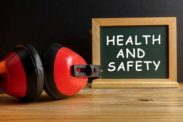 Gezondheid en veiligheidsconcept. Persoonlijke beschermingsmiddelen op hout — Stockfoto
