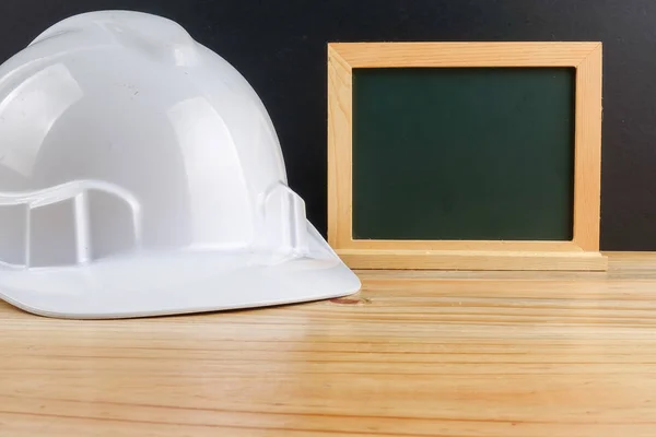 HEALTH AND SAFETY CONCEPT. Personal protective equipment on wooden table over black background.