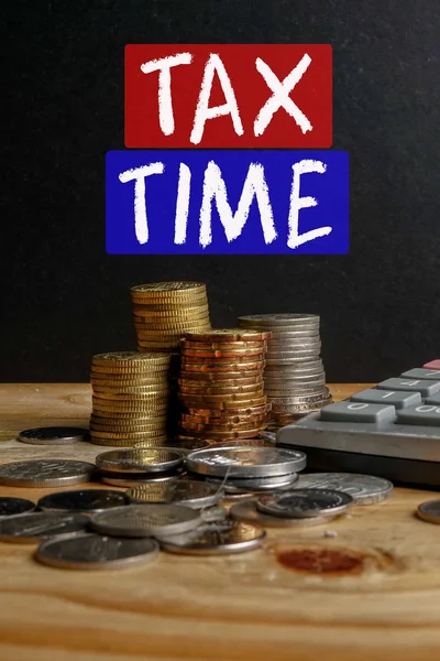 C'est l'heure de l'impôt. Empilement de pièces sur fond noir . — Photo