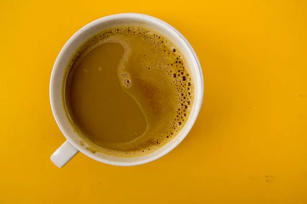 在黄色桌上查看一杯拿铁咖啡 — 图库照片