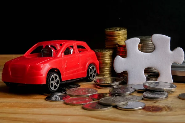 AUTO FINANCING CONCEPT : Small cars,coins,piece of puzzle and calculator on wooden table. Copy Space