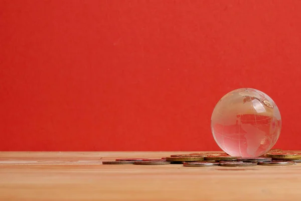 КОНЦЕПТ ГЛОБАЛЬНЫХ ФИНАНСОВ: Глобус и монеты на красном фоне — стоковое фото