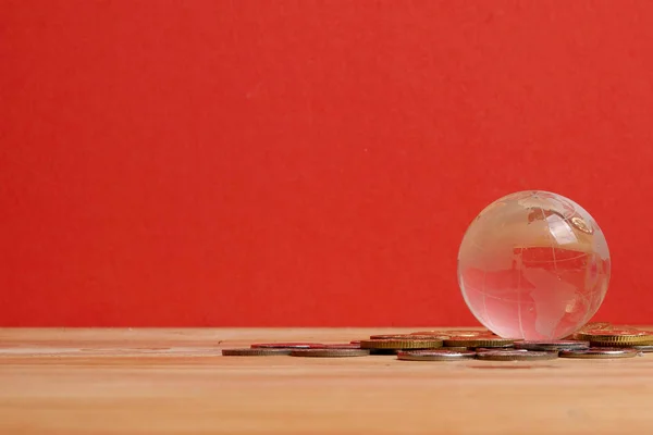 CONCEPT DE FINANCES MONDIALES : Globe and coins sur fond rouge — Photo