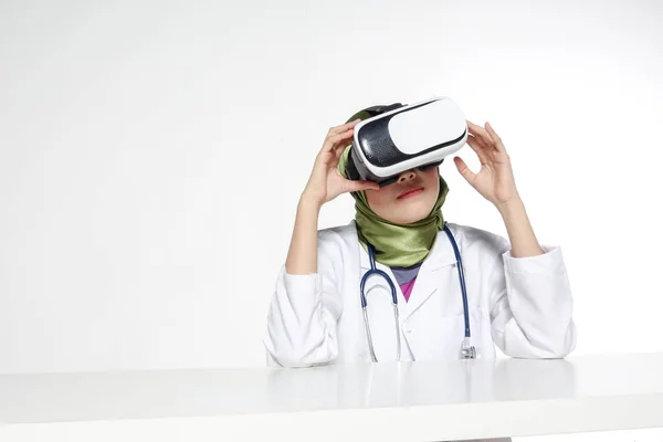 Female doctor wearing virtual reality glasses isolated on white background