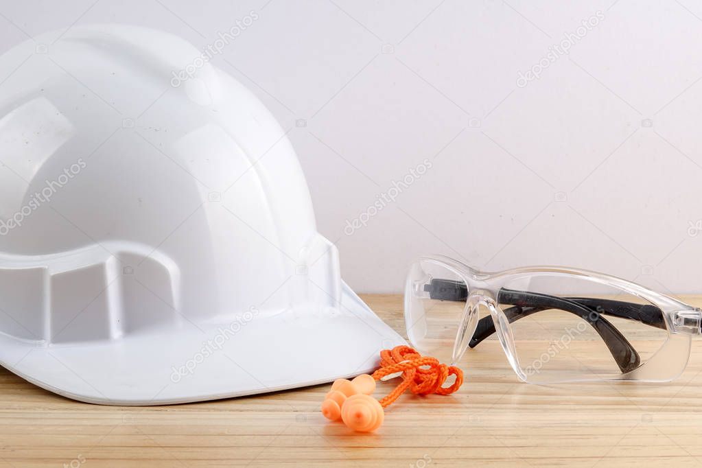 HEALTH AND SAFETY CONCEPT. Personal protective equipment on wooden table over white background.