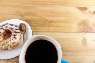 İş kavramı - üstten görünüm çörek, defter, kalem, kahve fincanı ve ahşap masa telefonu.