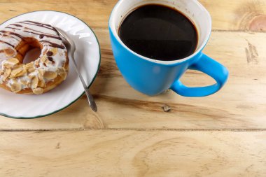 İş kavramı - üstten görünüm çörek, defter, kalem, kahve fincanı ve ahşap masa telefonu.