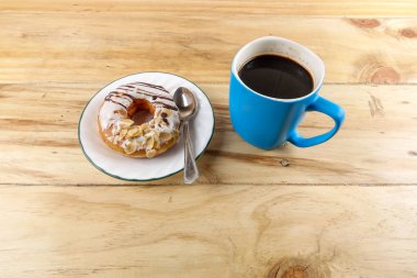 İş kavramı - üstten görünüm çörek, defter, kalem, kahve fincanı ve ahşap masa telefonu.