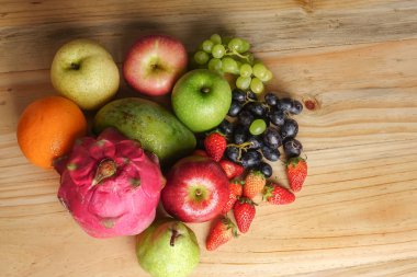 Ahşap masa üzerinde farklı meyve kümesi.