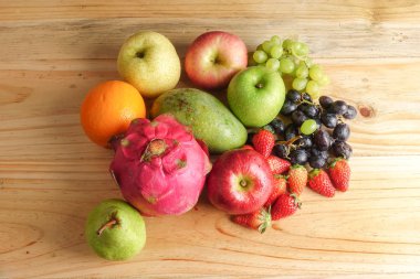 Ahşap masa üzerinde farklı meyve kümesi.