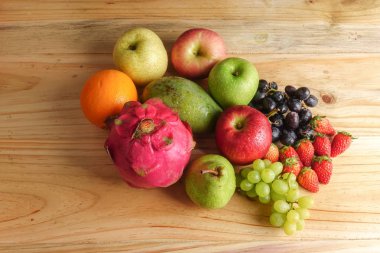 Ahşap masa üzerinde farklı meyve kümesi.