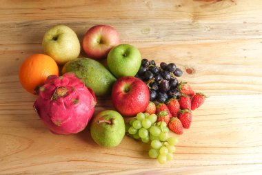 Ahşap masa üzerinde farklı meyve kümesi.