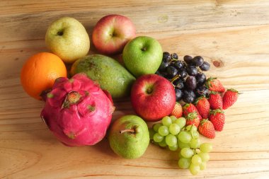 Ahşap masa üzerinde farklı meyve kümesi.