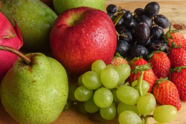 Ahşap masa üzerinde farklı meyve kümesi.