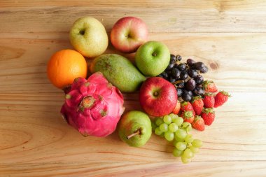 Ahşap masa üzerinde farklı meyve kümesi.