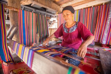 Lombok, Endonezya: 4 Haziran 2015 - Sasak yaşlı kadın geleneksel olarak iplik iğ tekerlek ile geleneksel Sasak köyünde, Desa Sasak Sade, Lombok Endonezya yapar.