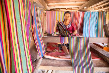 Lombok, Endonezya: 4 Haziran 2015 - Sasak yaşlı kadın geleneksel olarak iplik iğ tekerlek ile geleneksel Sasak köyünde, Desa Sasak Sade, Lombok Endonezya yapar.