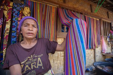Lombok, Endonezya: 4 Haziran 2015 - Sasak yaşlı kadın geleneksel olarak iplik iğ tekerlek ile geleneksel Sasak köyünde, Desa Sasak Sade, Lombok Endonezya yapar.