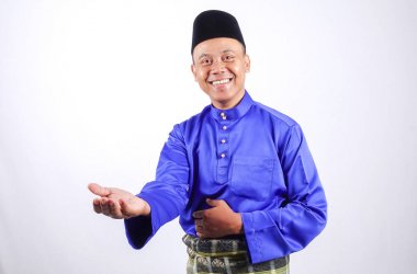 Genç Asyalı erkek tam kıyafetleri ile Baju Melayu (Ulusal Custome) Eid Mubarak kutlama için