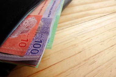 Malezya banknot ve ahşap arka plan üzerinde içinde kredi kartı ile erkekler açık cüzdan deri.