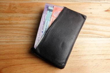 Malezya banknot ve ahşap arka plan üzerinde içinde kredi kartı ile erkekler açık cüzdan deri.