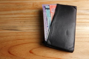 Malezya banknot ve ahşap arka plan üzerinde içinde kredi kartı ile erkekler açık cüzdan deri.