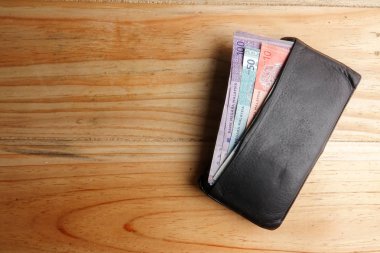 Malezya banknot ve ahşap arka plan üzerinde içinde kredi kartı ile erkekler açık cüzdan deri.