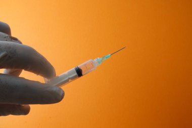 Sarı arka planda izole edilmiş aşı şırıngası ile tıbbi konsept.