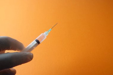 Sarı arka planda izole edilmiş aşı şırıngası ile tıbbi konsept.