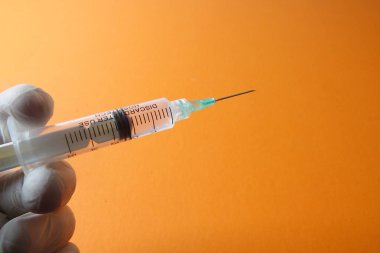 Sarı arka planda izole edilmiş aşı şırıngası ile tıbbi konsept.