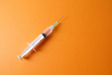 Sarı arka planda izole edilmiş aşı şırıngası ile tıbbi konsept.